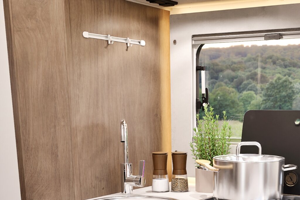 Carado motorhome kitchen area with sink, tap, spice mills and a window overlooking the greenery