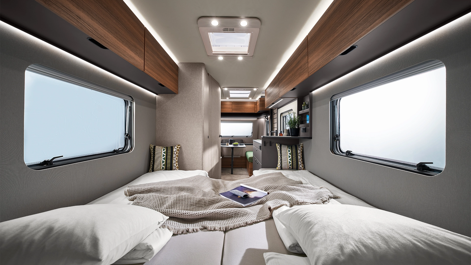 Liegefläche mit Decken und Kissen im Camperinnenraum