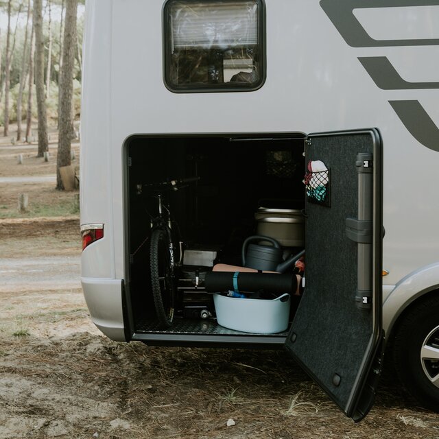Achtergarage van een HYMER camper geladen met fiets, gieter enz.