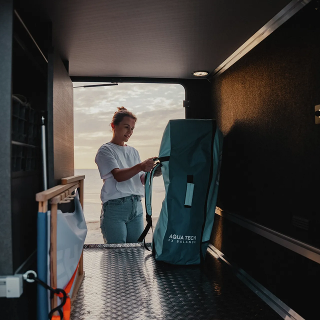 Man die een mountainbike uitlaadt uit de achterste garage van een HYMER camper