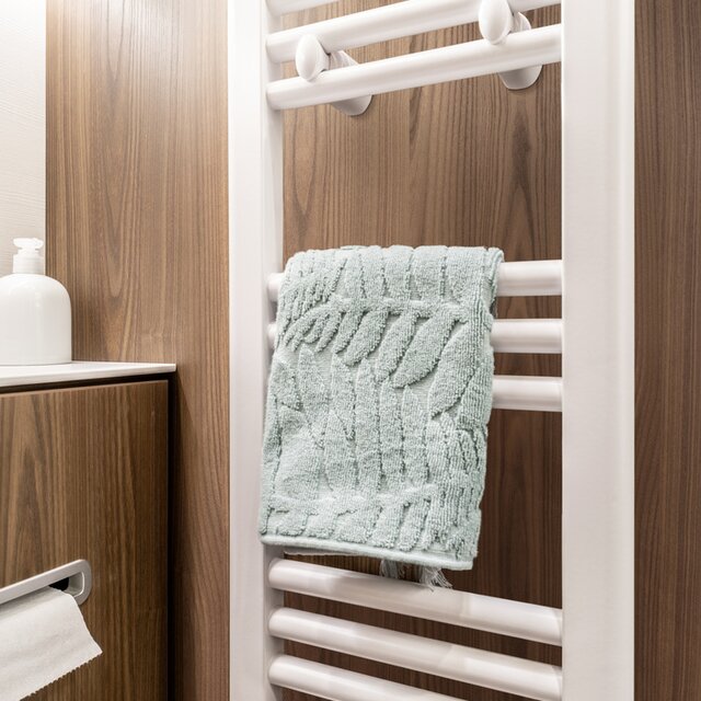 Handdoekradiator met opgeborgen handdoek in de salonbadkamer van de HYMER B MasterLine