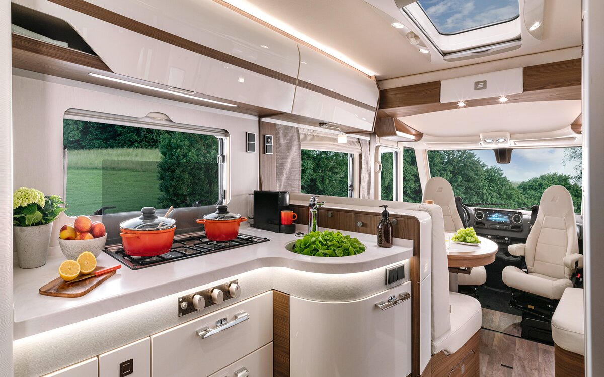 Licht keukenwerkblad met 3-pits kooktoestel en kookgerei in de HYMER-B MasterLine