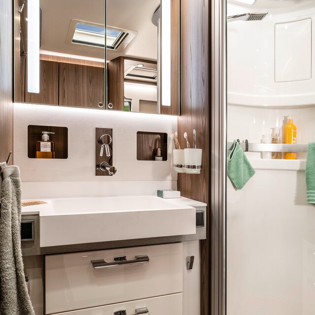 Salonbadkamer in de HYMER B-klasse MasterLine met indirect verlichte spiegelkast en lades onder de wastafel