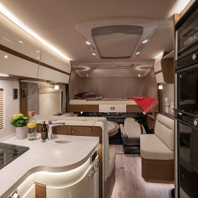 Verlaagbaar voorbed met rood dekbed en donkerrood sierkussen in de HYMER B-klasse MasterLine I 880
