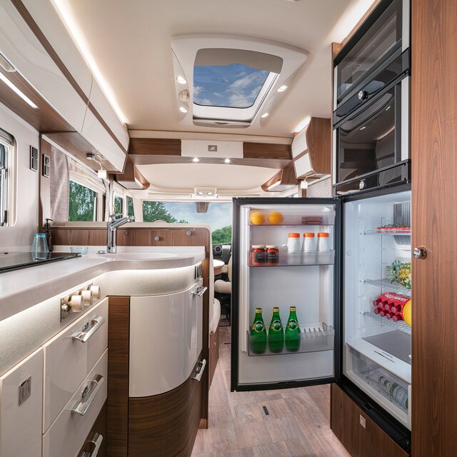 Gevulde, open koelkast tegenover het keukenwerkblad in de HYMER B-ML I 880