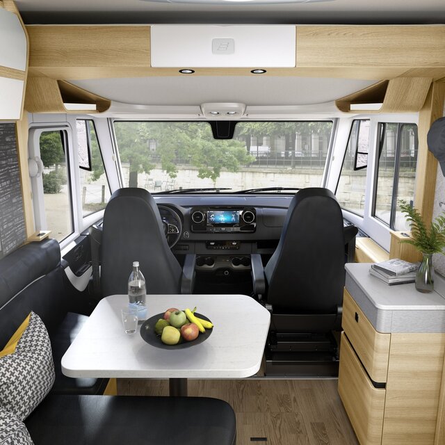 Gedecoreerd woongedeelte in de HYMER B-klasse MasterLine-camper met zwarte zithoek en lichtgekleurde meubels