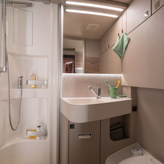 Comfort bathroom with shower cubicle, wash basin, mirror, storage cupboard and bathroom accessories in the HYMER Exsis 580