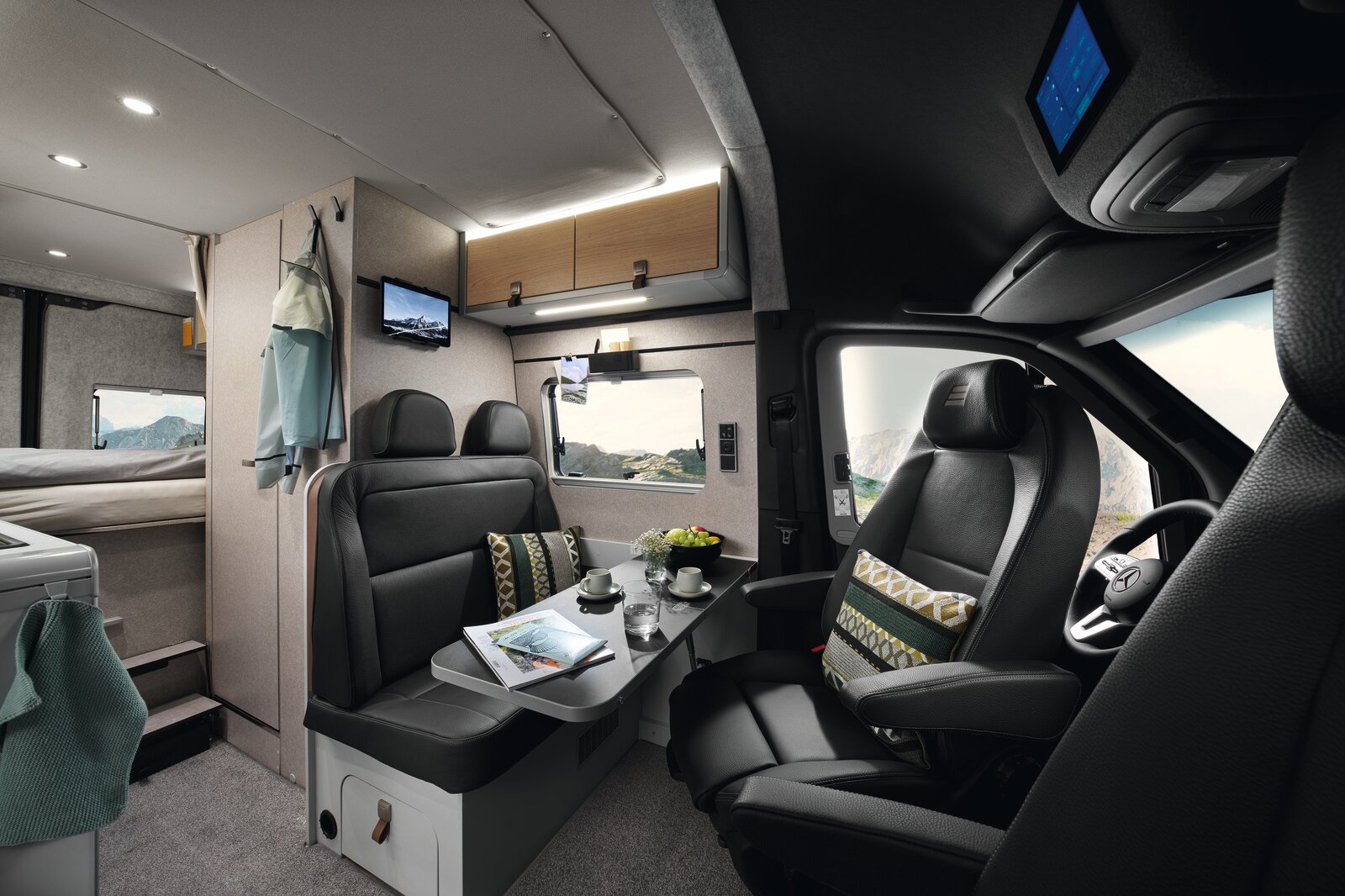 The living area of the HYMER Grand Canyon S in the Pearl Grey style world photographed from the passenger seat.