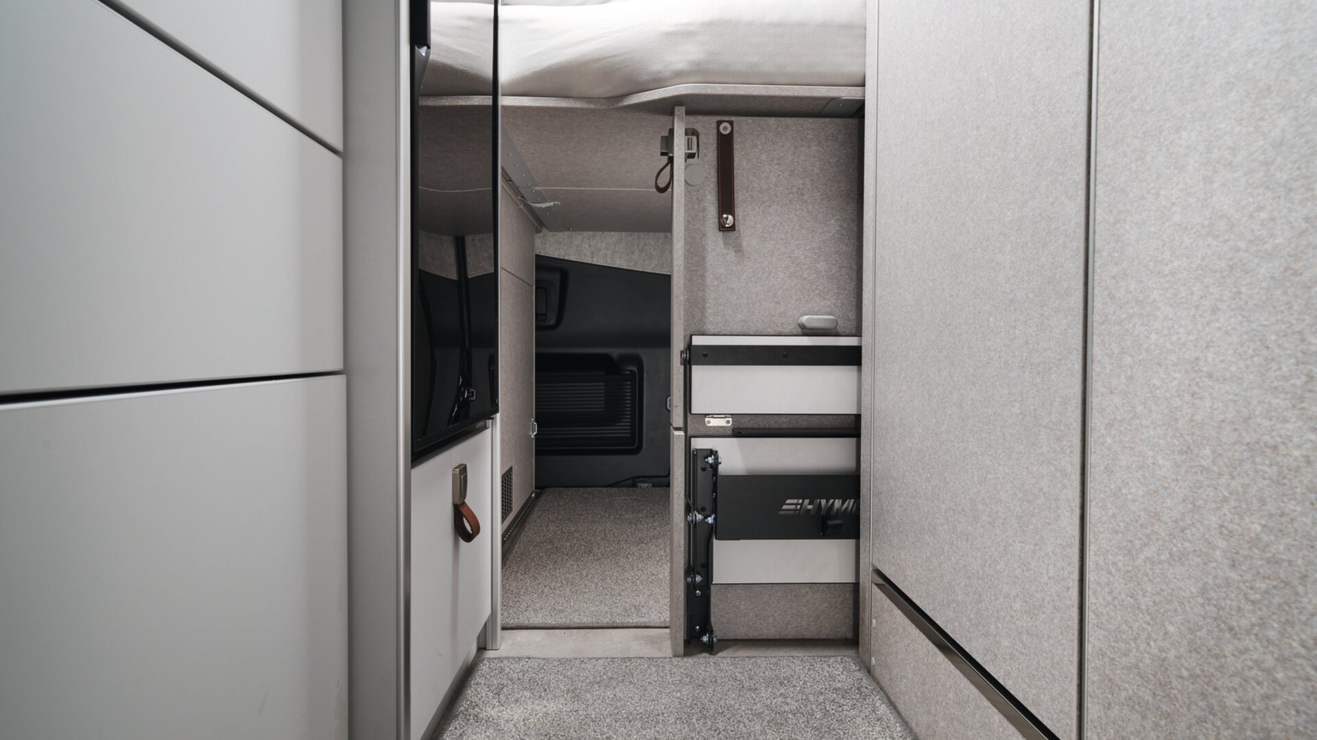 The step to the bed not only makes it easy to get into the rear bed, but also serves as a handy storage space partition. During the day, it can simply be pushed aside to make it easier to move around.