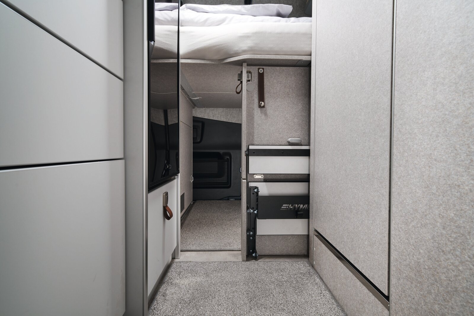 The step to the bed not only makes it easy to get into the rear bed, but also serves as a handy storage space partition. During the day, it can simply be pushed aside to make it easier to move around.