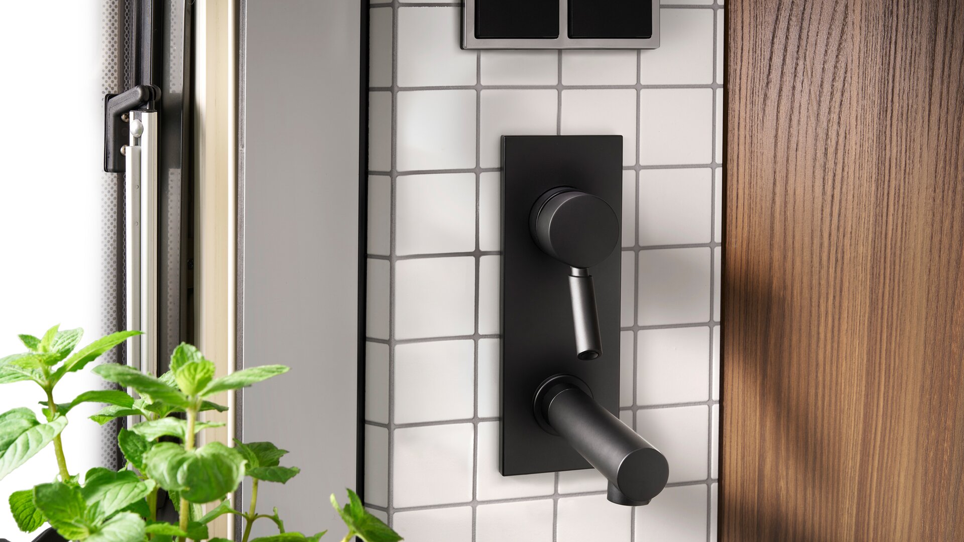 The backsplash with real tiles and matt black fittings are truly eye-catching.