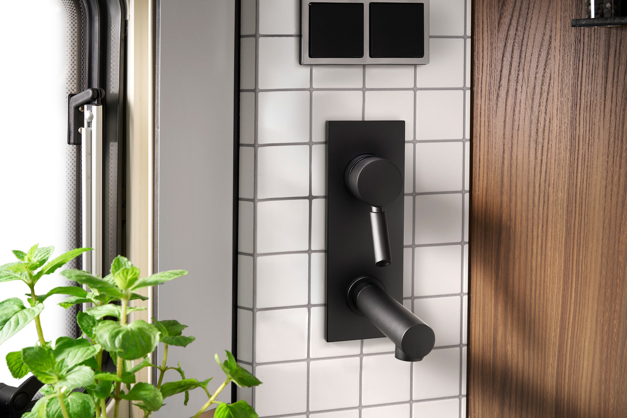 The backsplash with real tiles and matt black fittings are truly eye-catching.