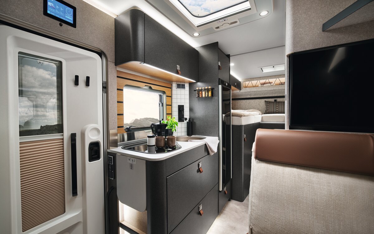 On the stove in the HYMER ML-T in the Velvet Ash style world, there is a pot. In front of it, partially visible, is the door, and above it is the HYMER Connect display.