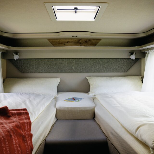 Covered lengthways single beds and red blanket in the rear of the HYMER Exsis 580 Pure