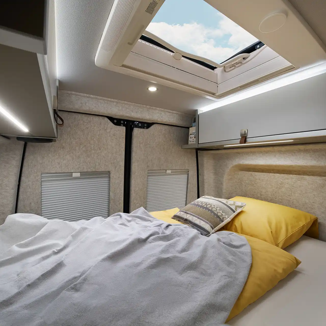 The sleeping area of the Grand Canyon S in the Pearl Grey style world is visible from the kitchen. The windows of the rear doors are darkened.