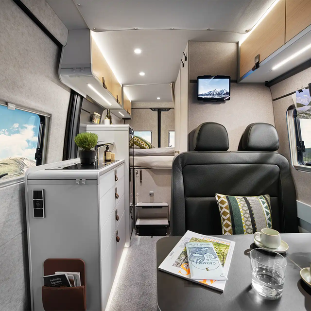 The view through the interior of the HYMER Grand Canyon in the Pearl Grey style world from the seating area to the sleeping area.