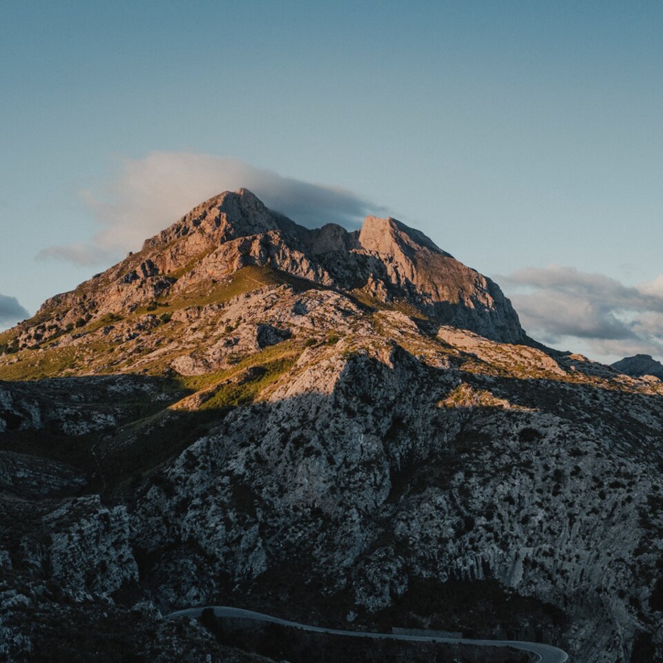 Utsikt från försidan av Venture S, med taket utfoldat, med fjäll och vatten i bakgrunden.